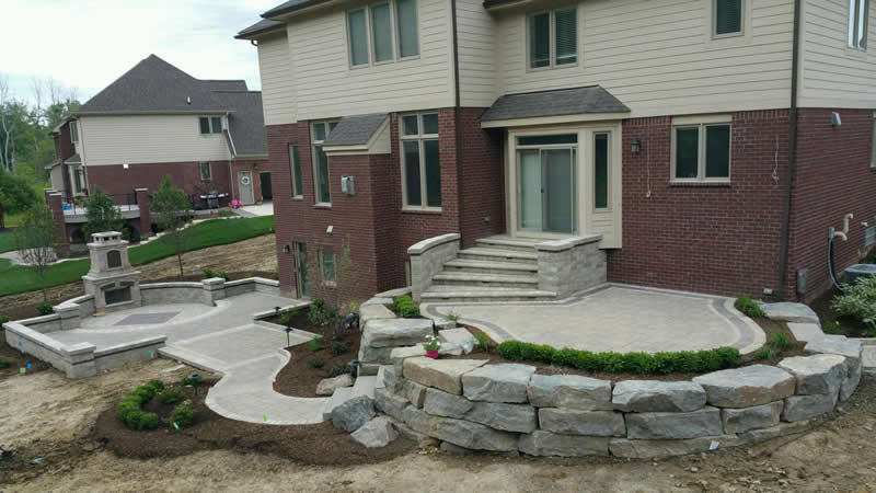 outdoor-living-space-stone-retaining-wall-paver-fireplace-patio